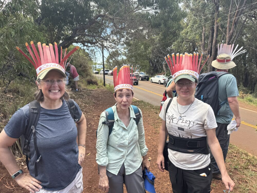 Three volunteers wearing ʻōhiʻa crowns