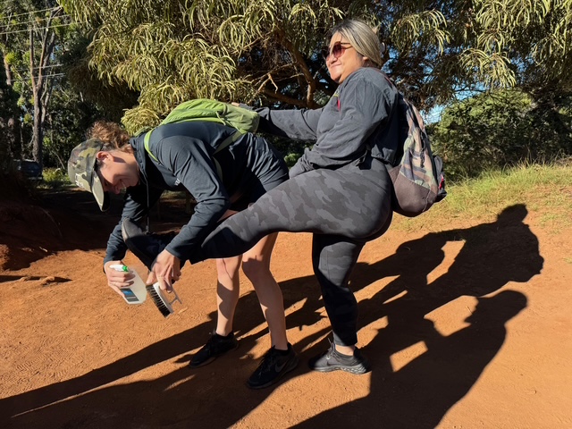 employees from keokiʻs paradise restaurant cleaning boots before heading down trail